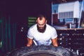 Muscular bearded fitness man moving large tire in the crossfit gym Royalty Free Stock Photo