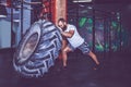 Muscular bearded fitness man moving large tire in the crossfit gym Royalty Free Stock Photo