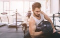 Muscular Bearded man during workout in the gym. Athlete muscular bodybuilder in the gym training biceps with dumbbell Royalty Free Stock Photo