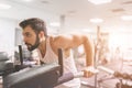 Muscular bearded man during workout in the gym. A portrait of a focused athletic male model in white clothes doing dips Royalty Free Stock Photo
