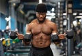 Muscular black guy doing workout with dumbbells at gym Royalty Free Stock Photo