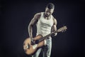 Muscular black man playing guitar