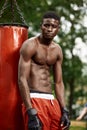 Muscular black professional boxer sweating in gloves boxing training outdoors, young african american boxer exercising Royalty Free Stock Photo