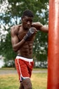 Muscular black professional boxer sweating in gloves boxing training outdoors, young african american boxer exercising Royalty Free Stock Photo