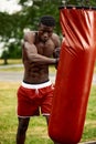 Muscular black professional boxer sweating in gloves boxing training outdoors, young african american boxer exercising Royalty Free Stock Photo