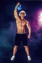 Muscular bodybuilder doing Exercise with kettlebell. Studio shot with smoke Royalty Free Stock Photo