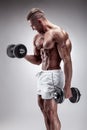 Muscular bodybuilder guy doing exercises with dumbbell Royalty Free Stock Photo