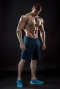 Muscular bodybuilder guy doing posing over black background Royalty Free Stock Photo