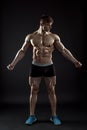 Muscular bodybuilder guy doing posing over black background Royalty Free Stock Photo