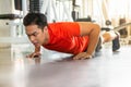 Muscular bodybuilder guy doing push ups exercise in fitness gym . young sport asian man training . workout