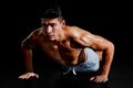 Muscular bodybuilder man doing push ups exercise isolated on black background with clipping path . Shirtless fitness young sport