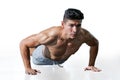 Muscular bodybuilder man doing push ups exercise isolated on white background with clipping path . Shirtless fitness young sport