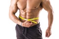 Muscular bodybuilder man measuring belly with tape measure Royalty Free Stock Photo