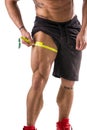 Muscular bodybuilder man measuring thigh with tape measure Royalty Free Stock Photo