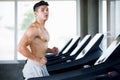 Muscular bodybuilder runner guy Exercise running on treadmill in the gym .sport young fitness man shirtless is working out Royalty Free Stock Photo