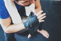 Muscular Boxer man prepairing hands for hard kickboxing training session in gym. Young athlete tying black boxing Royalty Free Stock Photo