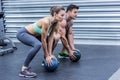 Muscular couple doing ball exercise