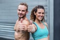 Muscular couple gesturing thumbs up