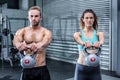 A muscular couple lifting kettlebells