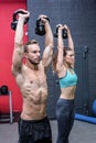 A muscular couple lifting kettlebells Royalty Free Stock Photo