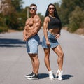 Muscular couple outdoors. Sporty man and woman showing muscles Royalty Free Stock Photo