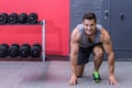 Male athlete getting into starting stance in gym with dumbbell rack and rubber floor, copy space Royalty Free Stock Photo