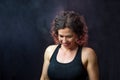 Muscular Female Trainer Looking Down With Backlit Chalk All Around