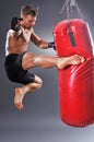 Muscular Fighter Practicing Some Kicks with Punching Bag.