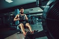Muscular fit man using rowing machine at gym Royalty Free Stock Photo