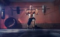 Muscular fitness man doing barbell lunges in his garage, selfisolation. Functional training. Snatch exercise Royalty Free Stock Photo