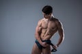 Muscular fitness young male antique perfect muscles six packs of abs and bare chest. Bodybuilder model trains with a stretching Royalty Free Stock Photo