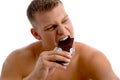 Muscular guy eating chocolate Royalty Free Stock Photo