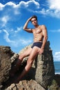 Muscular guy sitting on the rock, mediterranean Sea Royalty Free Stock Photo