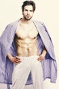 Muscular guy with torso and six packs in home or bath clothes. Morning and masculinity concept. Macho in blue bathrobe