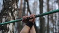 Muscular handsome guy with naked torso doing exercises in forest. Street workout. callisthenics