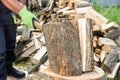 Muscular handsome young man in paint spattered jeans, sneakers and a bare chest standing chopping logs with an axe on a grey Royalty Free Stock Photo