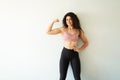 Portrait of a happy woman in her 20s doing a bicep pose Royalty Free Stock Photo