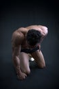 Muscular male bodybuilder kneeling with head down Royalty Free Stock Photo