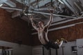 Muscular male crossfit athlete working out on gymnastic rings