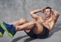 Muscular male fitness athlete doing sit ups while smiling Royalty Free Stock Photo