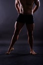 Muscular male legs, man in studio, dark background Royalty Free Stock Photo