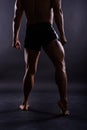 Muscular male legs, man in studio, dark background Royalty Free Stock Photo