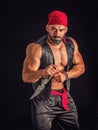 Muscular male pirate in studio shot, wearing bandana and open vest