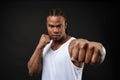 Muscular man of African descent isolated over a black background showing a closeup of his fists and knuckles. Shallow