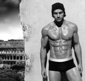 Muscular man against wall with Rome in background
