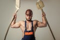 muscular man architect in engineer boilersuit and protective hard hat hold shovel, construction site Royalty Free Stock Photo