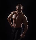 Muscular man on black background in studio