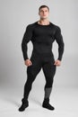 Muscular man in black compression sportswear on gray background Royalty Free Stock Photo