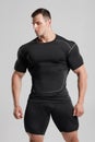 Muscular man in black compression sportswear on gray background Royalty Free Stock Photo