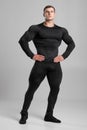 Muscular man in black compression sportswear on gray background Royalty Free Stock Photo